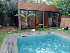 On aperçoit le studio avec les tapis de yoga depuis le jardin